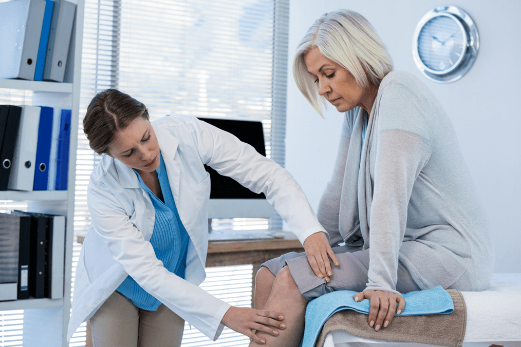 Лекар прегледа пацијента са артрозом коленског зглоба
